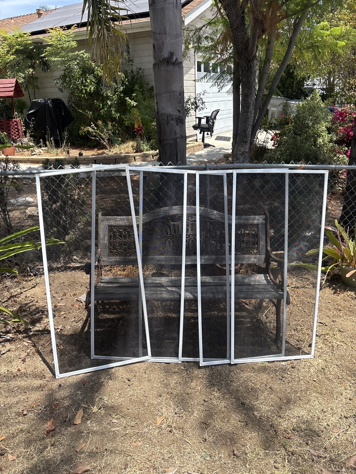 A set of window screen frames staged in a Spring Valley yard, ready to be re-screened on site by Window Screens Repair